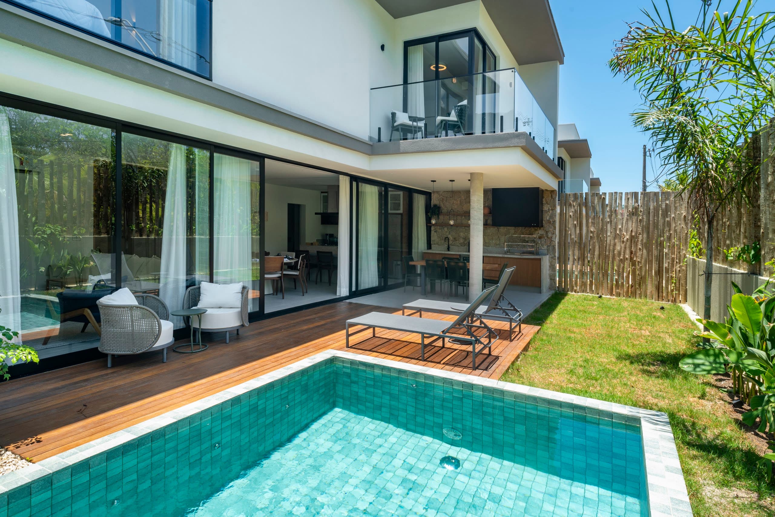 Piscina e deck de uma das casas, com a varanda do pavimento superior